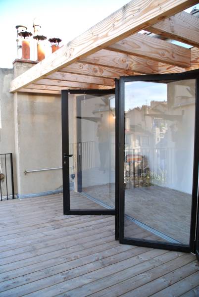 Casa Menuiserie Effet dedans/dehors d’une baie accordéon Solarlux sur une terrasse moderne à Marseille
