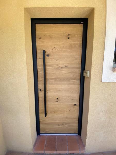 Casa Menuiserie Porte d'entrée en bois huilé avec barre de tirage à Bouc Bel Air.